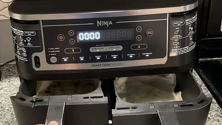 Hand pulling out basket of the Ninja Foodi DZ550 Air Fryer for cleaning